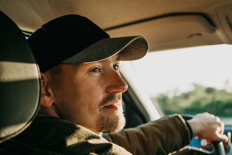 man looking out the window while driving