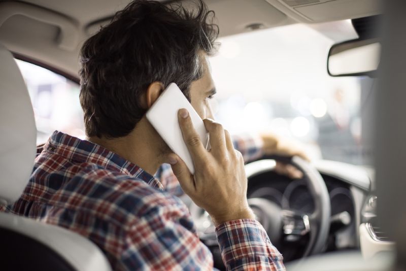 rear view of a man on the phone while driving