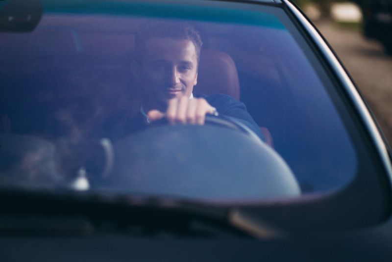 Man driving in the evening time with a smirk on his face