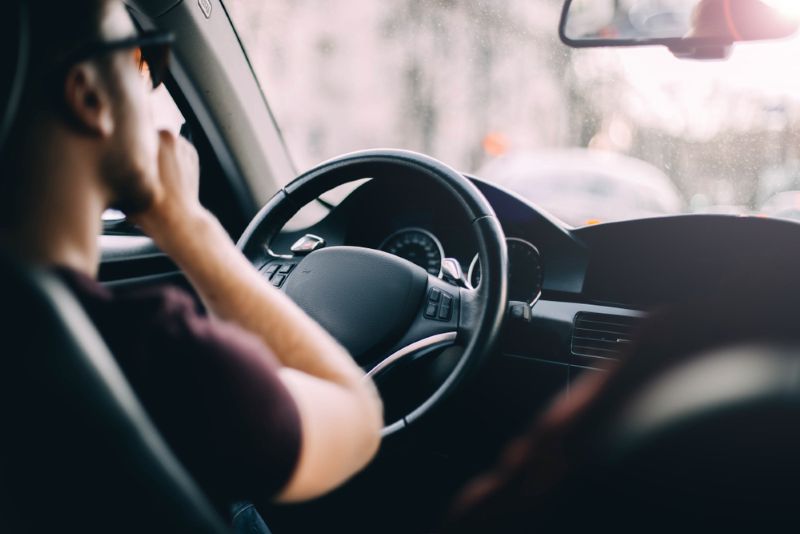 Rear view of a man driving a car