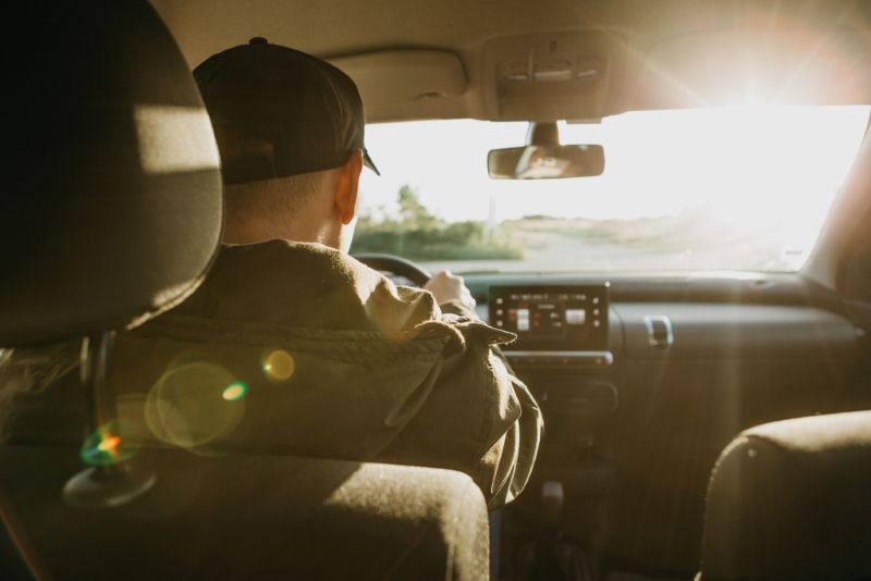 Man driving car during sunset